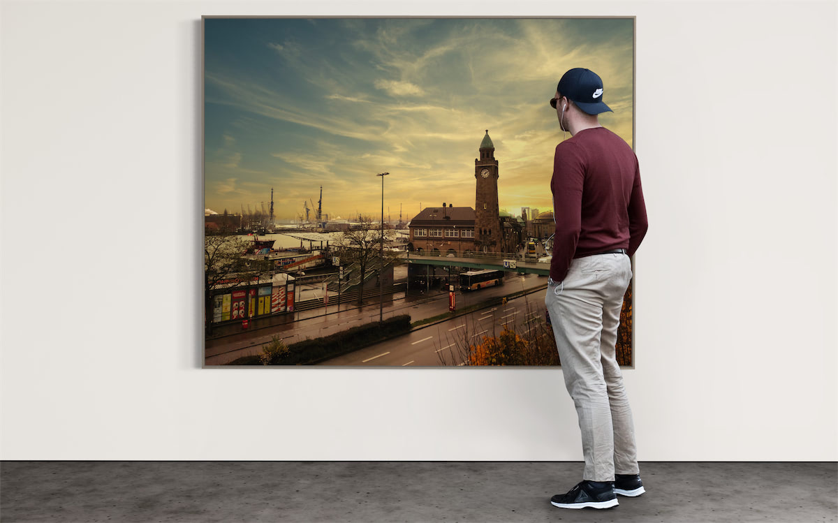 Mann  steht vor einem Foto mit dem Motiv Hamburger Landungsbrücken